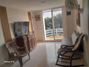 a living room with a couch and chairs and a tv at Confortable y comodo apartamento in Cartagena de Indias