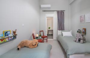 una habitación con 2 camas con un osito de peluche sobre ellas en Nasos Aegina Apartment, en Aegina Town