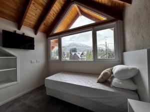 a bedroom with a bed and a large window at ENDOR en VLA in Villa La Angostura