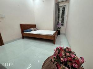 a room with a bed and a table with flowers at lizhome in Da Nang