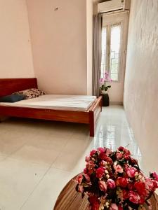 a bedroom with a bed and a bouquet of roses at lizhome in Da Nang