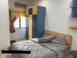 sypialnia z łóżkiem oraz niebiesko-żółtą szafką w obiekcie Thind's Place w mieście Kamunting