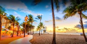 a beach with palm trees and the ocean at sunset at Villa Ft Lauderdale XL Pool, playground, BBQ, beach, Family Paradise in Fort Lauderdale