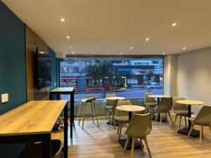 a restaurant with tables and chairs and a large window at Hotel HILLS BOGOTA in Bogotá