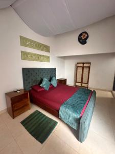 a bedroom with a bed and a table and a clock at HOTEL RENASCI PALOMINO in Palomino