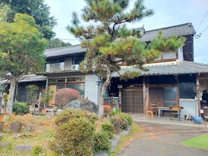 a house with a pine tree in front of it at kamino Terrace, a Japanese history and nature experience accommodation in Wakakuri