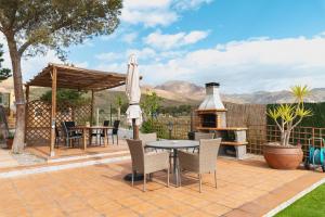 a patio with a table and chairs and a fireplace at Cortijo El Pinar 1 in Níjar