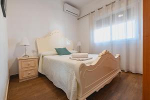 a bedroom with a white bed and a window at Cortijo El Pinar 1 in Níjar +46 photos