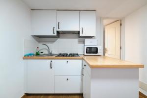 a kitchen with white cabinets and a microwave at Cortijo El Pinar 1 in Níjar
