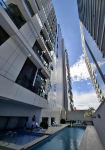 a building with a swimming pool in front of a building at Studio premium próximo a Alphaville in Barueri