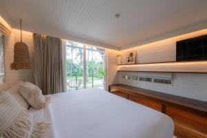 Un dormitorio con una gran cama blanca y una ventana. en Hotel Lumi Gili Trawangan, en Gili Trawangan 37 fotos más