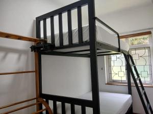 Letto a castello nero in camera con finestra di Kandy Twin Hostel a Kandy