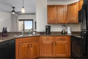 a kitchen with wooden cabinets and a sink at Club Wyndham Bonnet Creek in Orlando