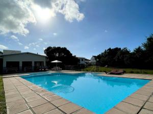 a large blue swimming pool in a yard at 173 at The Dunes in Keurboomstrand