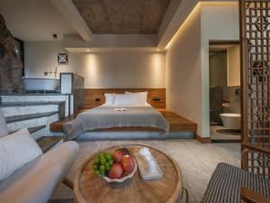 een slaapkamer met een bed en een fruitschaal op een tafel bij 兴义市田景宜色客栈 in Nahui