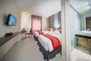 a hotel room with a large bed and a sink at Serela Cihampelas by KAGUM Hotels in Bandung +48 photos