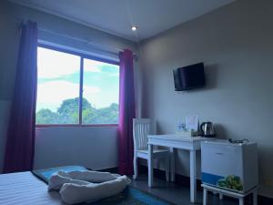 白马市Au Paradis Bleu Hotel的一间卧室，里面有一张床、一张桌子和一扇窗户