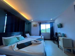 白马市Au Paradis Bleu Hotel的蓝色灯的客房内的两张床
