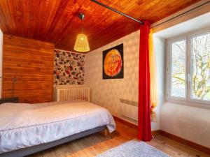 a bedroom with a bed and a wooden ceiling at Maison à Génos pour 8, proche lac, jardin et poêle à bois - FR-1-695-73 in Génos