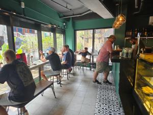 a group of people sitting at tables in a restaurant at Mad Monkey Manila in Manila