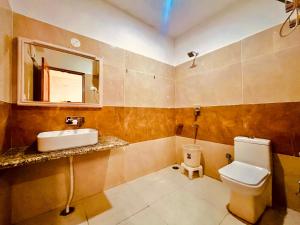 un bagno con lavandino, water e specchio di The Kartik Villa, Manali - A Beautiful Cottage in the Clouds towards Snow Capped Mountains a Manāli