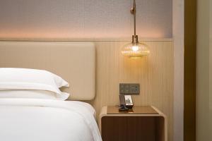 Postel nebo postele na pokoji v ubytování Chengdu Echeng Hotel Chunxi Road Taikoo Li