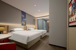 Postel nebo postele na pokoji v ubytování Chengdu Echeng Hotel Chunxi Road Taikoo Li