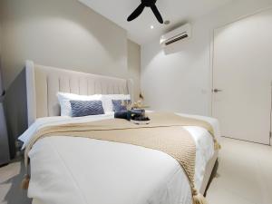 a white bedroom with a large white bed with a ceiling at Arcoris Mont Kiara in Kuala Lumpur