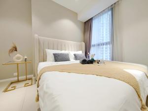 a white bedroom with a large bed with a window at Arcoris Mont Kiara in Kuala Lumpur