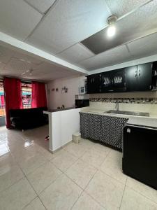 a kitchen with black cabinets and a white counter top at Casa Irene in Chinchiná