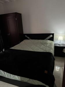a bedroom with a bed with a black headboard and a night stand at Casa Irene in Chinchiná +22 photos
