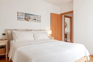 a bedroom with a large white bed with white sheets at Cozy Retreat in Coastal Livorno in Livorno