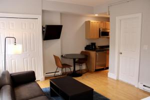 a living room with a couch and a table and a kitchen at Stylish Downtown Studio in the SouthEnd, C.Ave# 2 in Boston