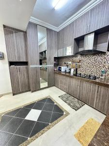 a kitchen with wooden cabinets and a tile floor at Harryna Homestay Damansara Damai in Petaling Jaya