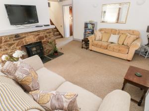 a living room with a couch and a fireplace at Barn Court Cottage in Narberth