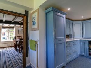 a kitchen with blue cabinets and a dining room at Bakehouse Farm in Princes Risborough