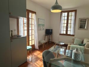 un salon avec un canapé et une table dans l'établissement Maison Cozy au Coeur de Cabourg avec Terrasse, Proche Plage, pour 4 Pers., Animaux Acceptés - FR-1-487-328, à Cabourg
