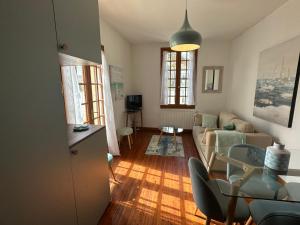 un salon avec un canapé et une table dans l'établissement Maison Cozy au Coeur de Cabourg avec Terrasse, Proche Plage, pour 4 Pers., Animaux Acceptés - FR-1-487-328, à Cabourg
