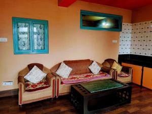 a living room with two couches and a table at Stay by Tenzing Rock in Darjeeling
