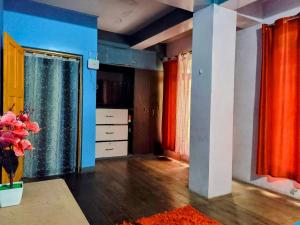 a room with blue and red curtains and a vase of flowers at Stay by Tenzing Rock in Darjeeling