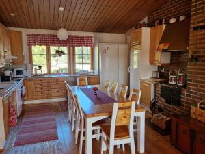 a kitchen with a wooden table and chairs in it at Villa Korpikallio in Naantali
