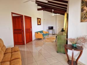 a living room with a couch and a table at Villa cinq cents pas in Sainte-Anne