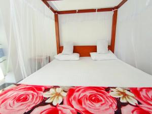a bedroom with a bed with flowers on it at Yokel View Villa in Weligama