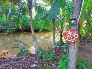 a sign on a pole next to a body of water at Yokel View Villa in Weligama