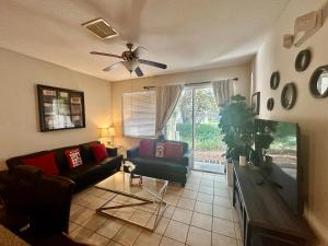 ein Wohnzimmer mit einer Couch und einem Deckenventilator in der Unterkunft Grand Panoramic 3BR Townhouse Near Disney Parks in Kissimmee