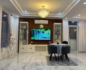 a dining room with a table and a tv on a wall at Elmo & Alice Villa Resort in Ginatilan
