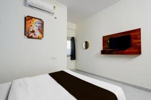 海得拉巴Super Hotel O RUBY GRAND INN的卧室配有一张床,墙上配有电视。