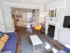 ein Wohnzimmer mit einer blauen Couch und einem Kamin in der Unterkunft Kestrel in Southwold