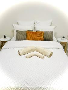 La Villa Des Lys avec jacuzzi في سان دوني: سرير ابيض عليه وسادتين