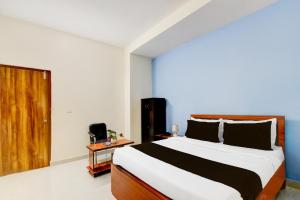 海得拉巴Super Hotel O RUBY GRAND INN的一间卧室设有一张大床和一扇木门